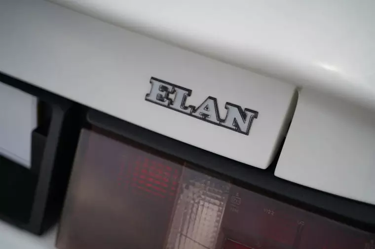 Dettaglio del badge posteriore con la scritta Elan su una Lotus Elan M100 bianca.