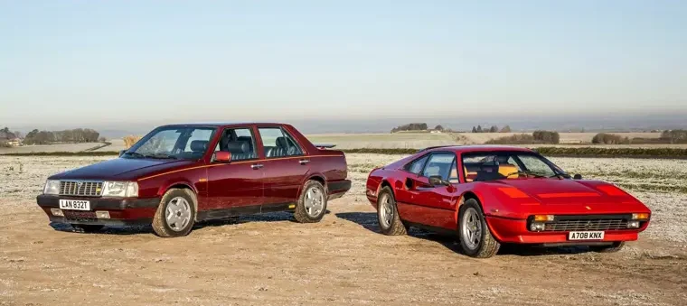 Lancia Thema 8.32 Rosso Winner affiancata a una Ferrari 308 rossa in aperta campagna