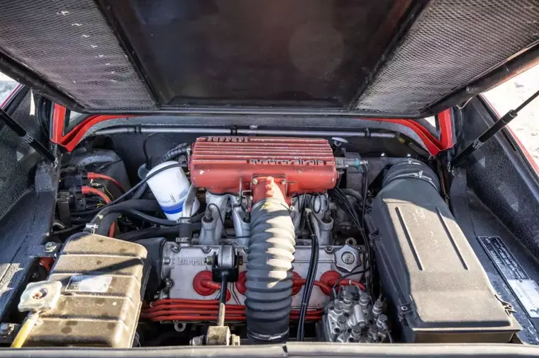 Vano motore aperto di una Ferrari 308 Quattrovalvole V8 con dettagli rossi