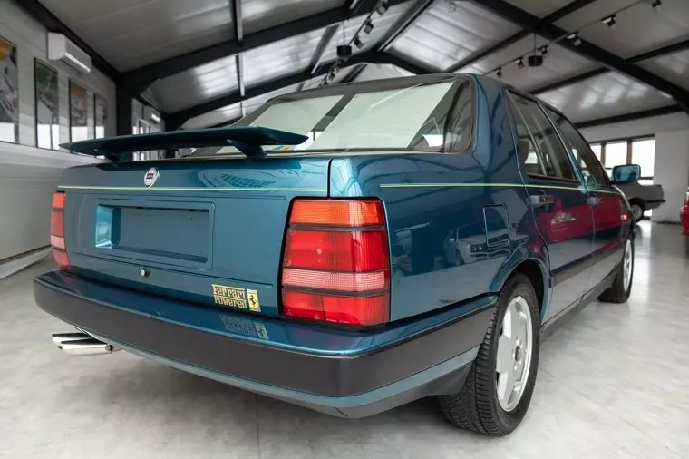 Vista di tre quarti posteriore di una Lancia Thema 8.32 Verde Reflex con alettone retrattile alzato